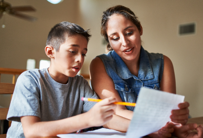 A woman and a young boy work together on homework